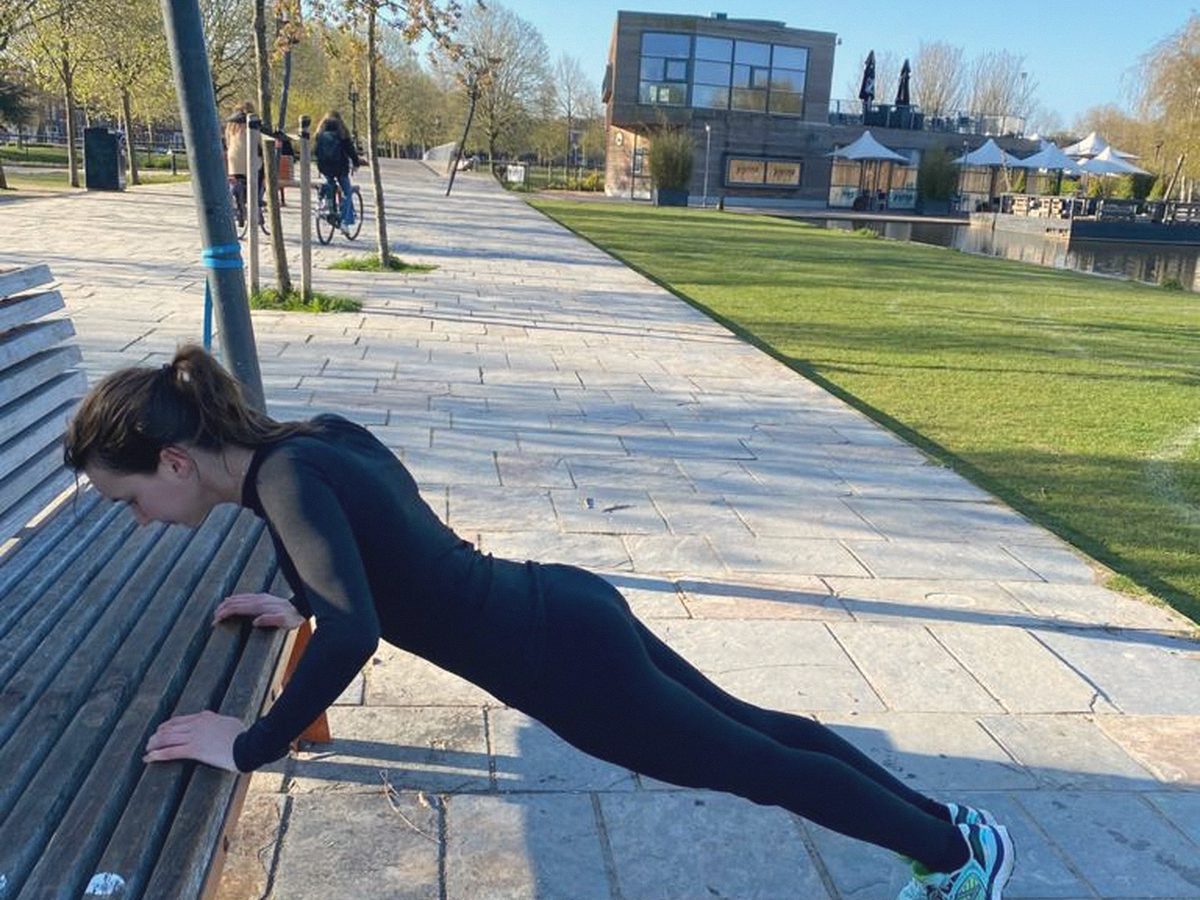 Iemand doet een oefening op een parkbankje
